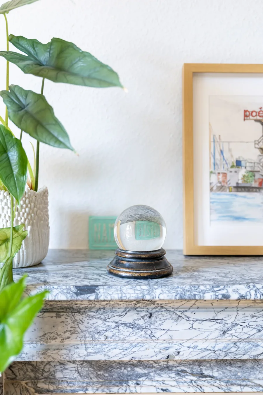 Objet en cristal et illustration encadrée sur la cheminée du cabinet