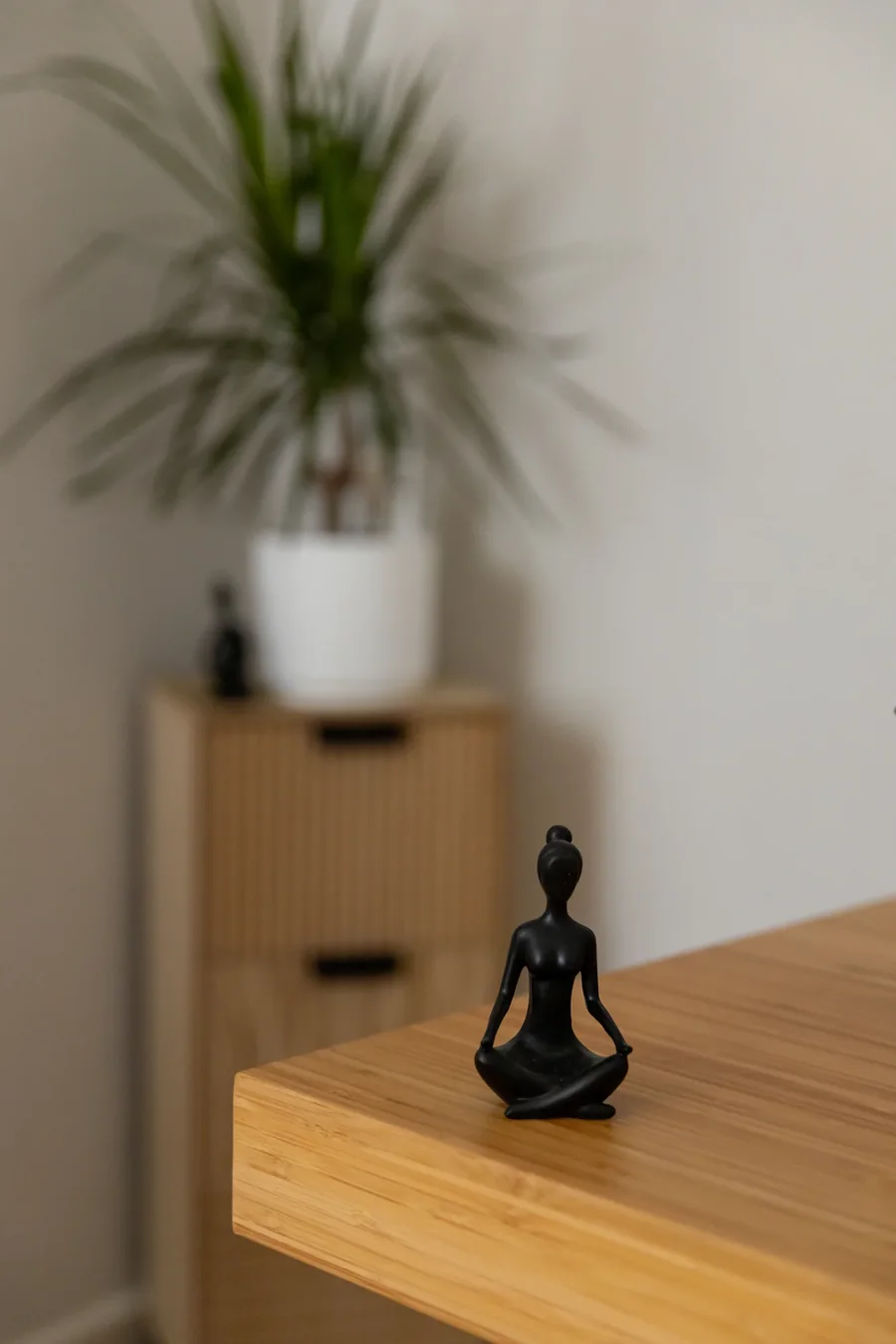 Statuette en méditation posée sur un plan en bois
